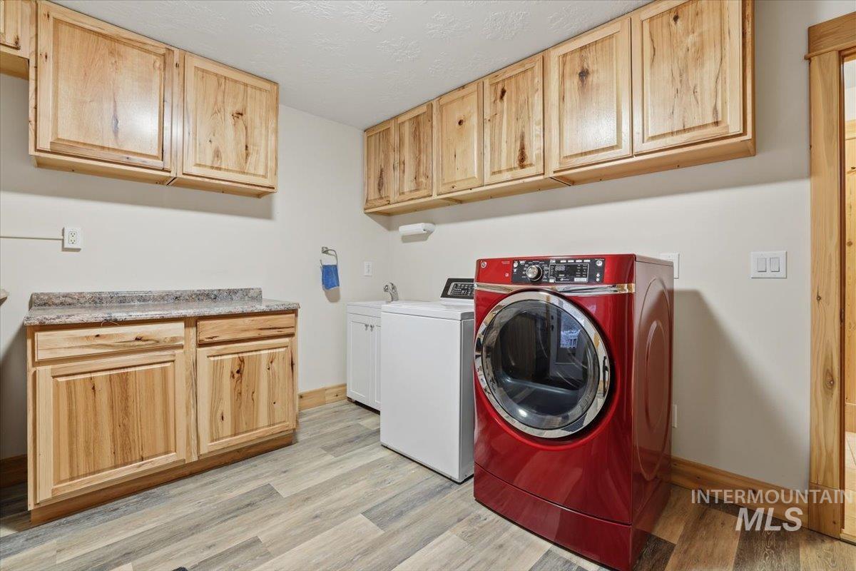 20 Valley High Road Garden Valley, ID 83622 - Photo 31 of 46 Laundry area featuring light wood-style floors, cabinet space, and a textured ceiling