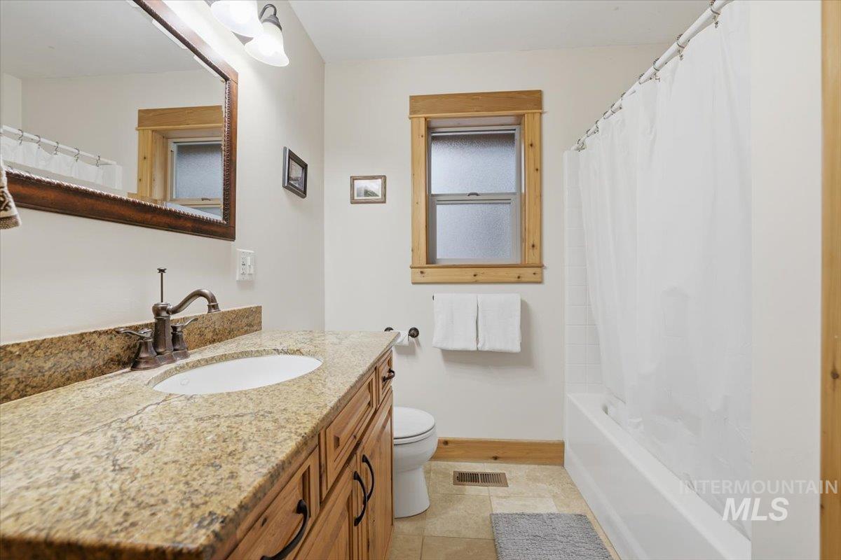 20 Valley High Road Garden Valley, ID 83622 - Photo 32 of 46 Bathroom with vanity and shower / bath combination with curtain