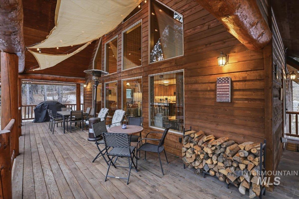 20 Valley High Road Garden Valley, ID 83622 - Photo 38 of 46 Wooden deck featuring outdoor dining area, grilling area, and a sunroom