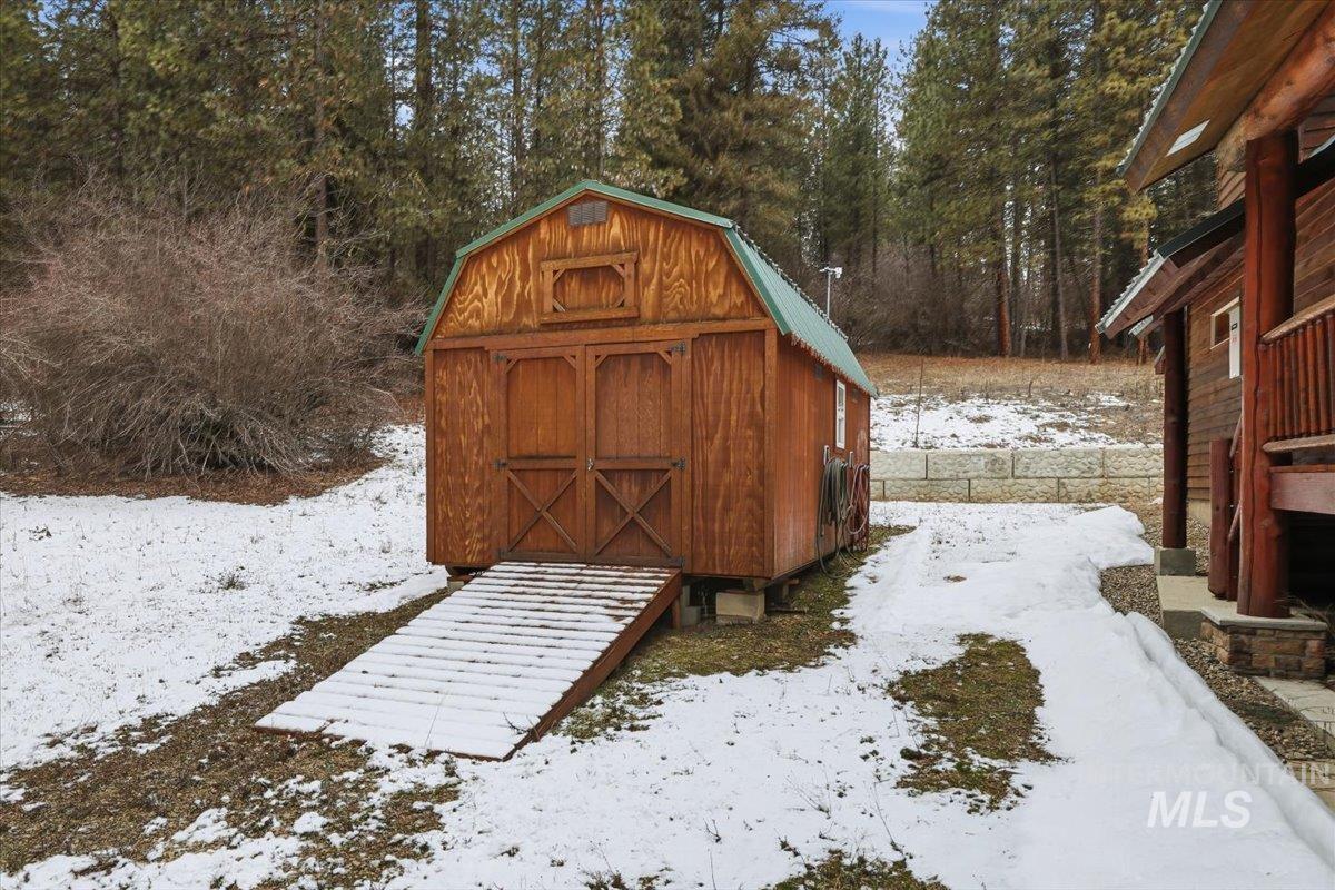 20 Valley High Road Garden Valley, ID 83622 - Photo 41 of 46 Snow covered structure featuring a storage shed and view of scattered trees