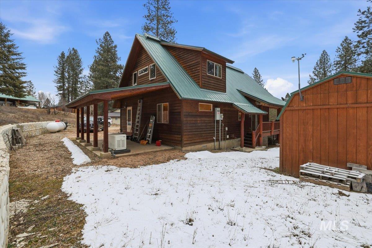 20 Valley High Road Garden Valley, ID 83622 - Photo 42 of 46 Snow covered back of property with a metal roof, covered porch, and an outdoor structure