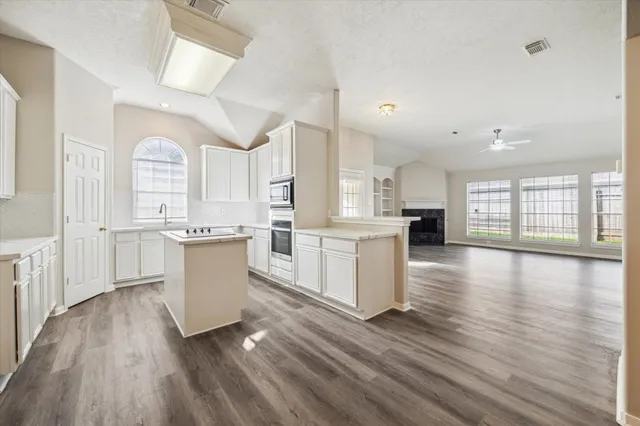 a kitchen with a white cabinets and wooden floor