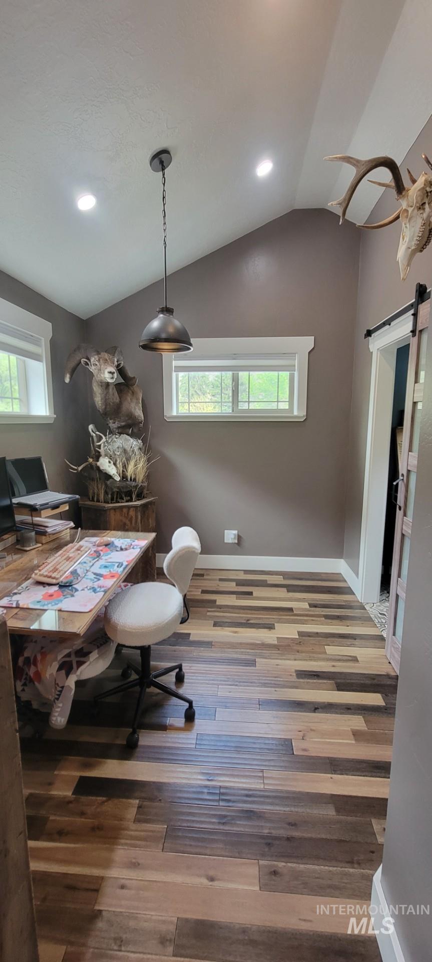 1006 Borah Avenue Riggins, ID 83549 - Photo 15 of 23 Office area with a barn door, recessed lighting, lofted ceiling, hardwood / wood-style flooring, and plenty of natural light