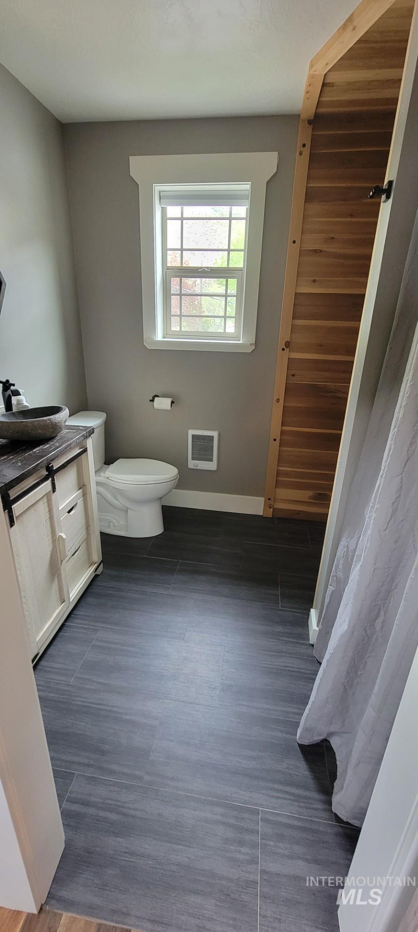 1006 Borah Avenue Riggins, ID 83549 - Photo 17 of 23 Bathroom featuring vanity, heating unit, and dark wood-type flooring
