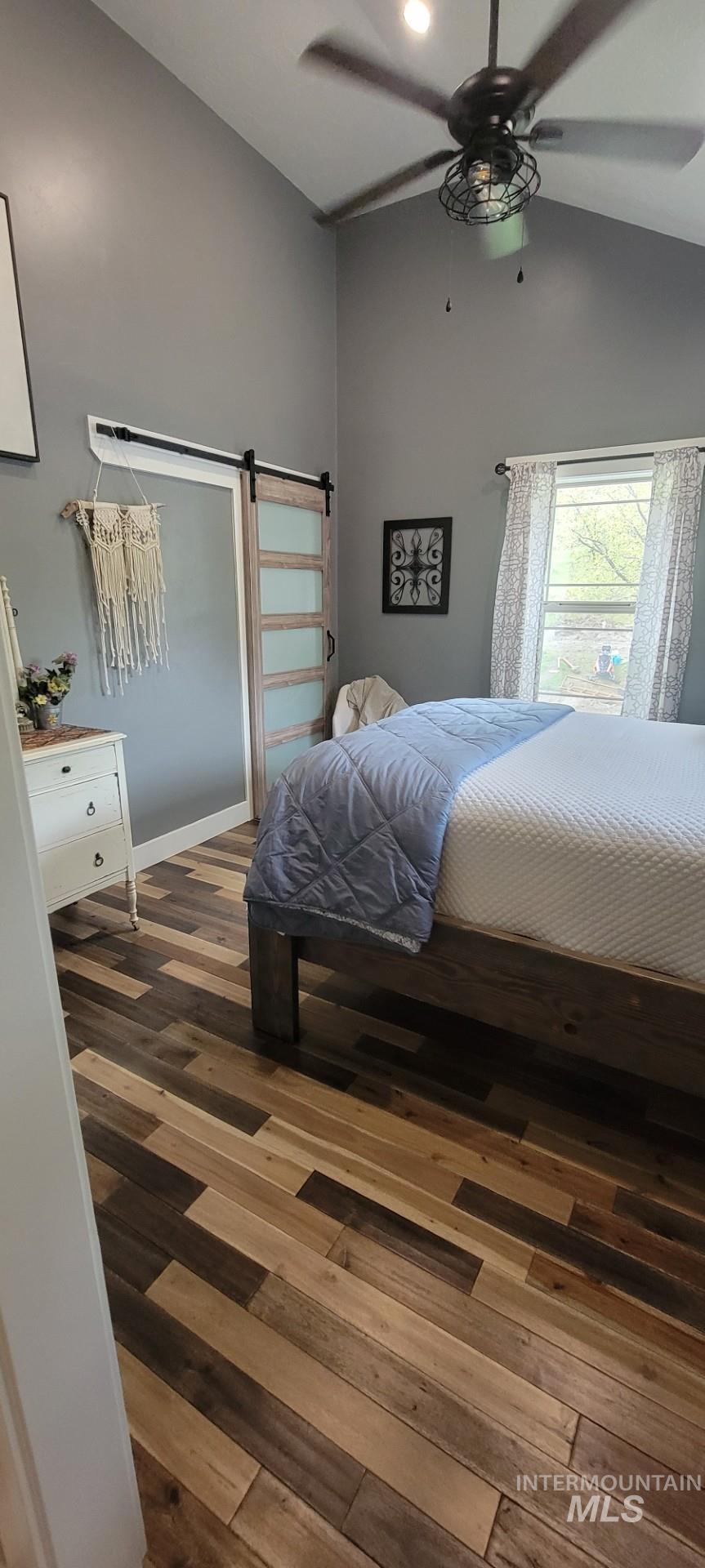 1006 Borah Avenue Riggins, ID 83549 - Photo 20 of 23 Bedroom featuring dark wood-style flooring, a barn door, a ceiling fan, and lofted ceiling