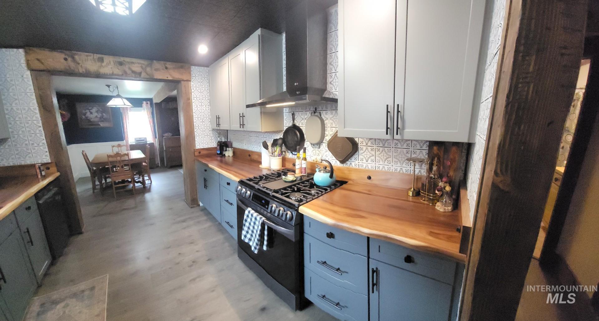 1006 Borah Avenue Riggins, ID 83549 - Photo 9 of 23 Kitchen featuring wood counters, range with gas cooktop, dishwashing machine, light wood finished floors, and two tone cabinetry