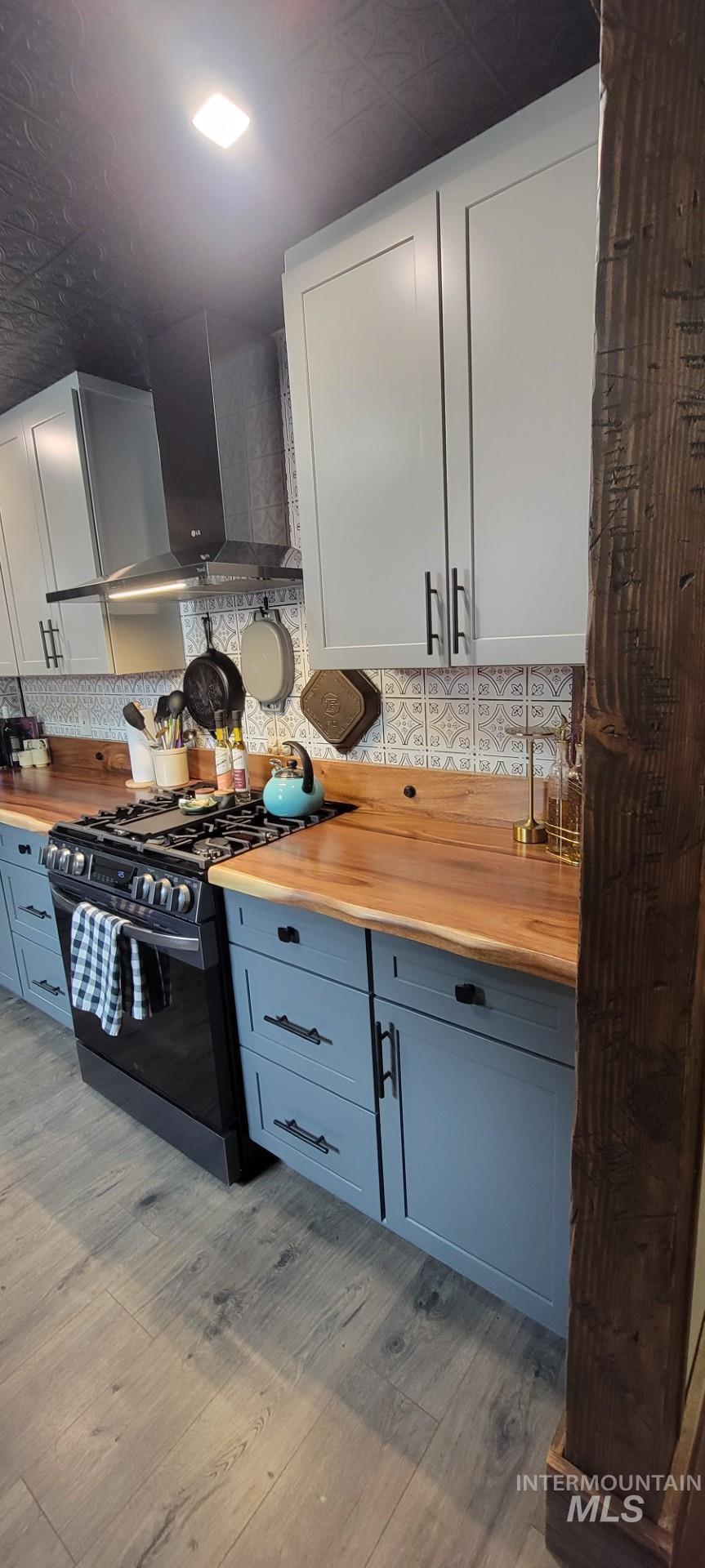 1006 Borah Avenue Riggins, ID 83549 - Photo 10 of 23 Two tone kitchen with wooden counters, black gas range, two tone color scheme, and light wood-type flooring