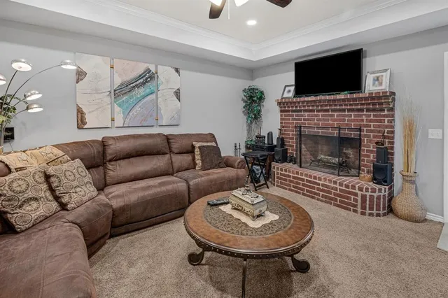 a living room with furniture a flat screen tv and a fireplace