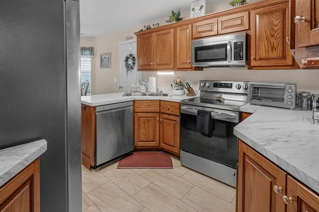 a kitchen with stainless steel appliances granite countertop a stove microwave and sink