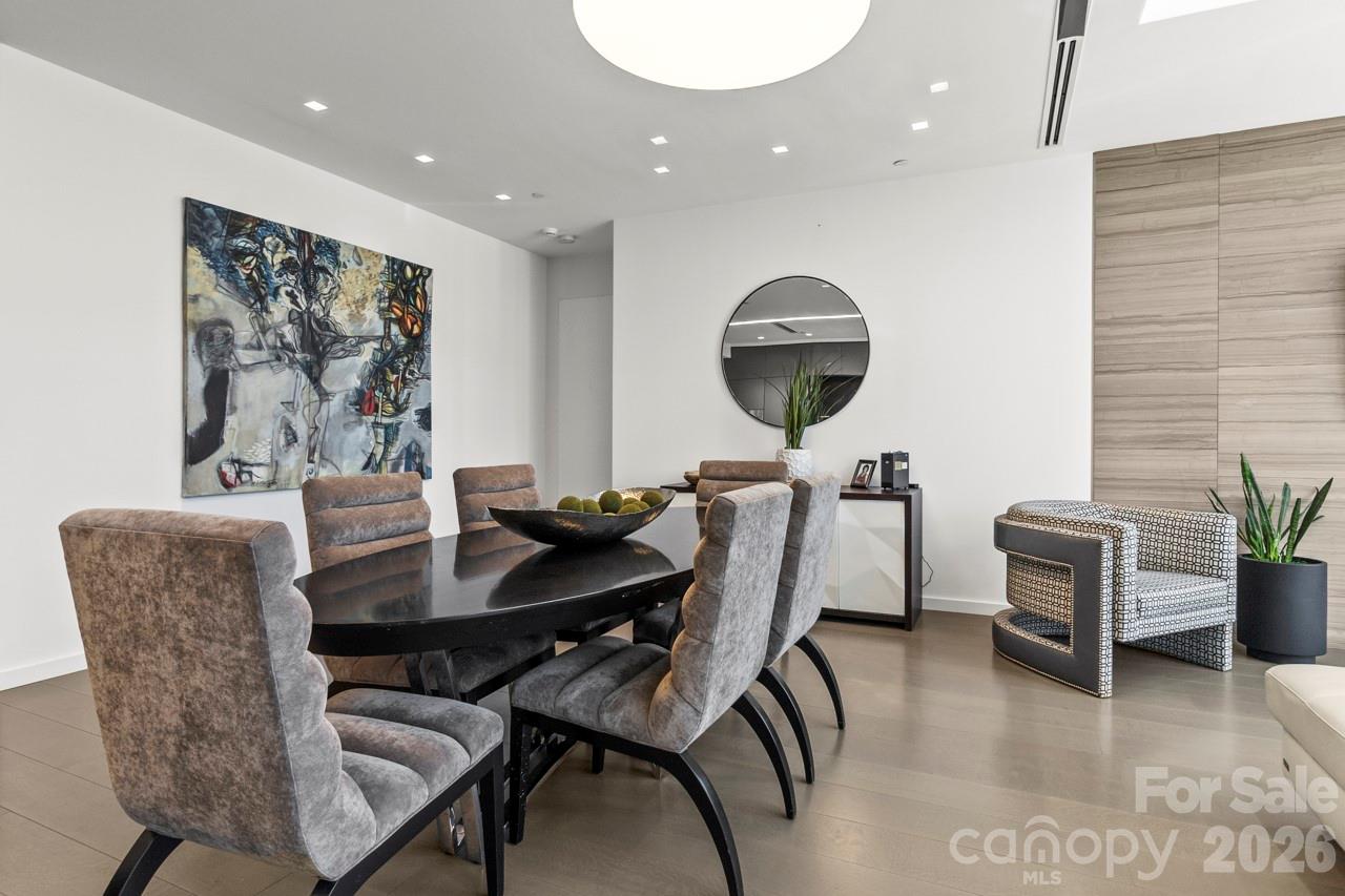 435 South Tryon Street, Unit 901 Charlotte, NC 28202 - Photo 11 of 28 a view of a dining room with furniture and wooden floor