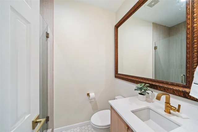 a bathroom with a sink vanity mirror and toilet