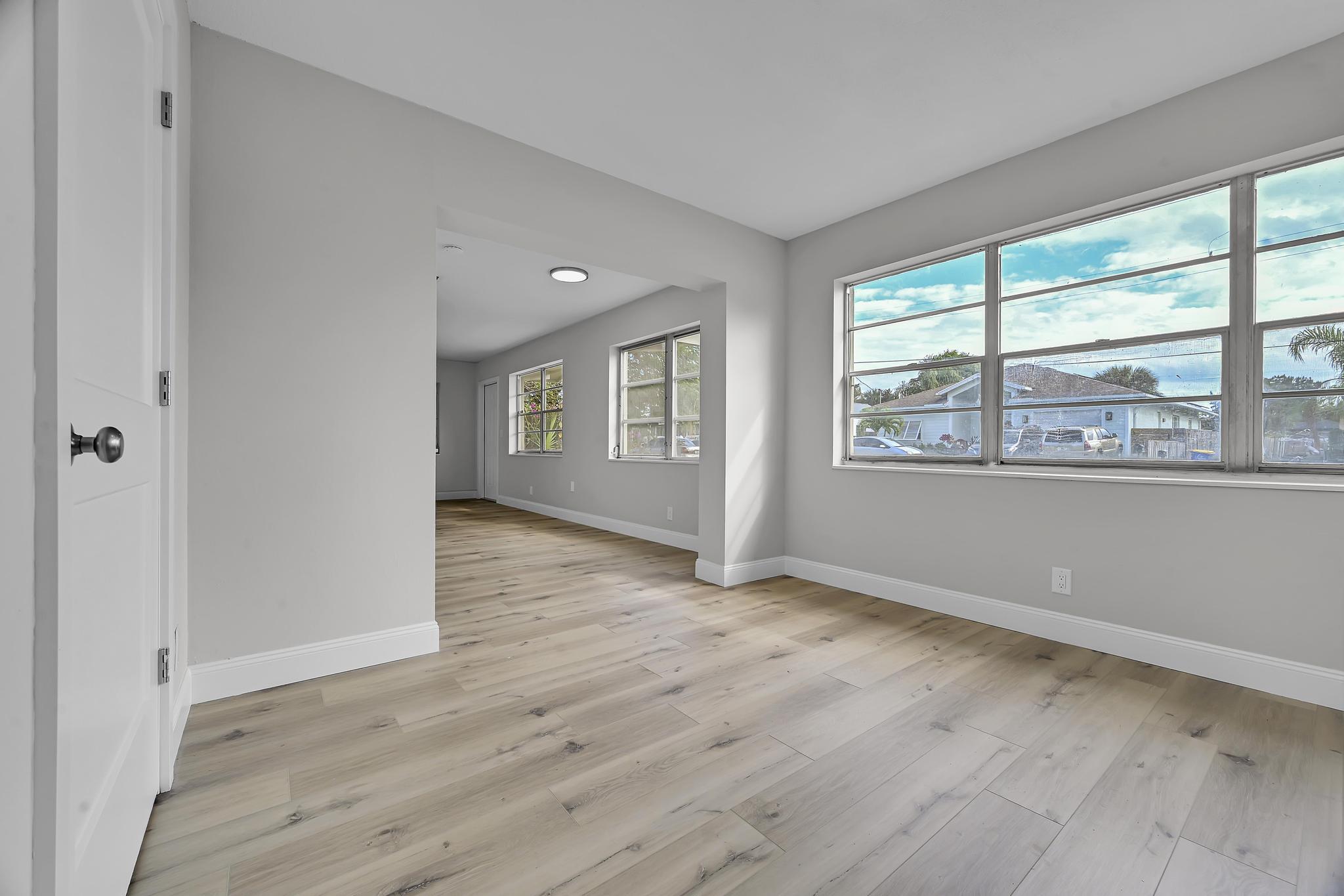 8487 Southeast Begonia Way Hobe Sound, FL 33455 - Photo 11 of 26 a view of an empty room with wooden floor and a window