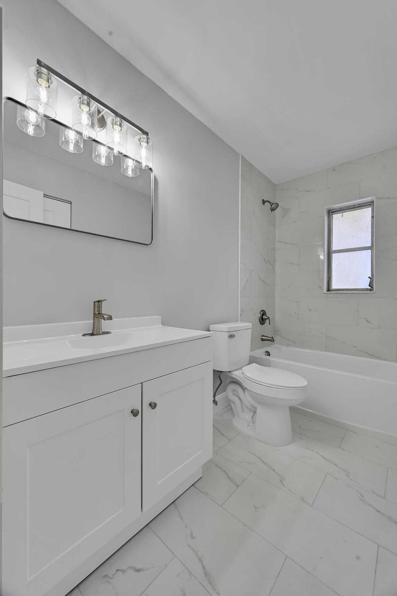 8487 Southeast Begonia Way Hobe Sound, FL 33455 - Photo 12 of 26 a bathroom with a toilet a sink and mirror