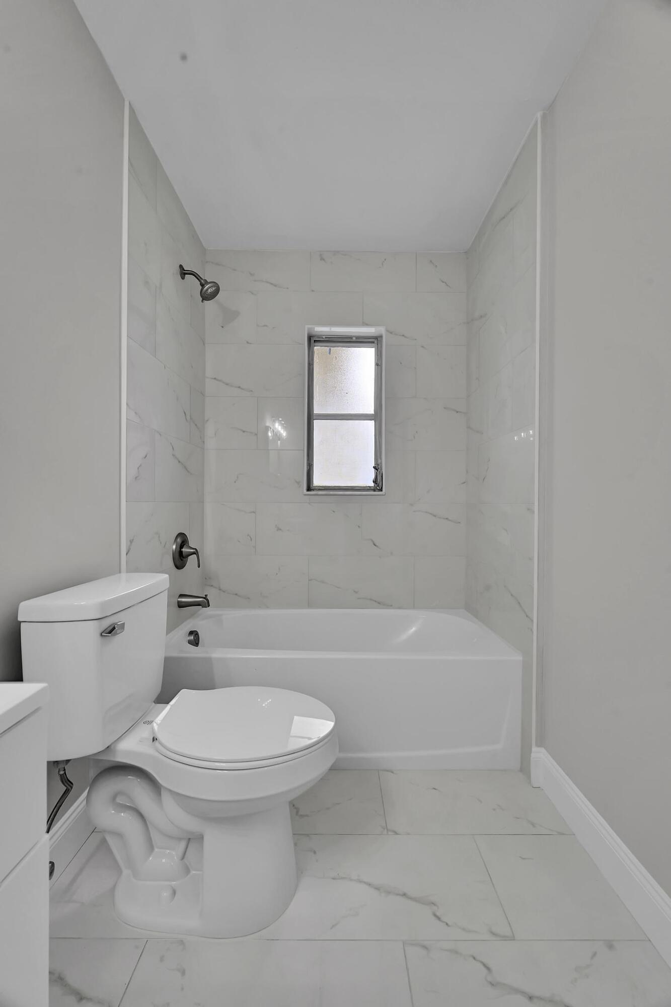 8487 Southeast Begonia Way Hobe Sound, FL 33455 - Photo 13 of 26 a white toilet sitting next to a bath tub