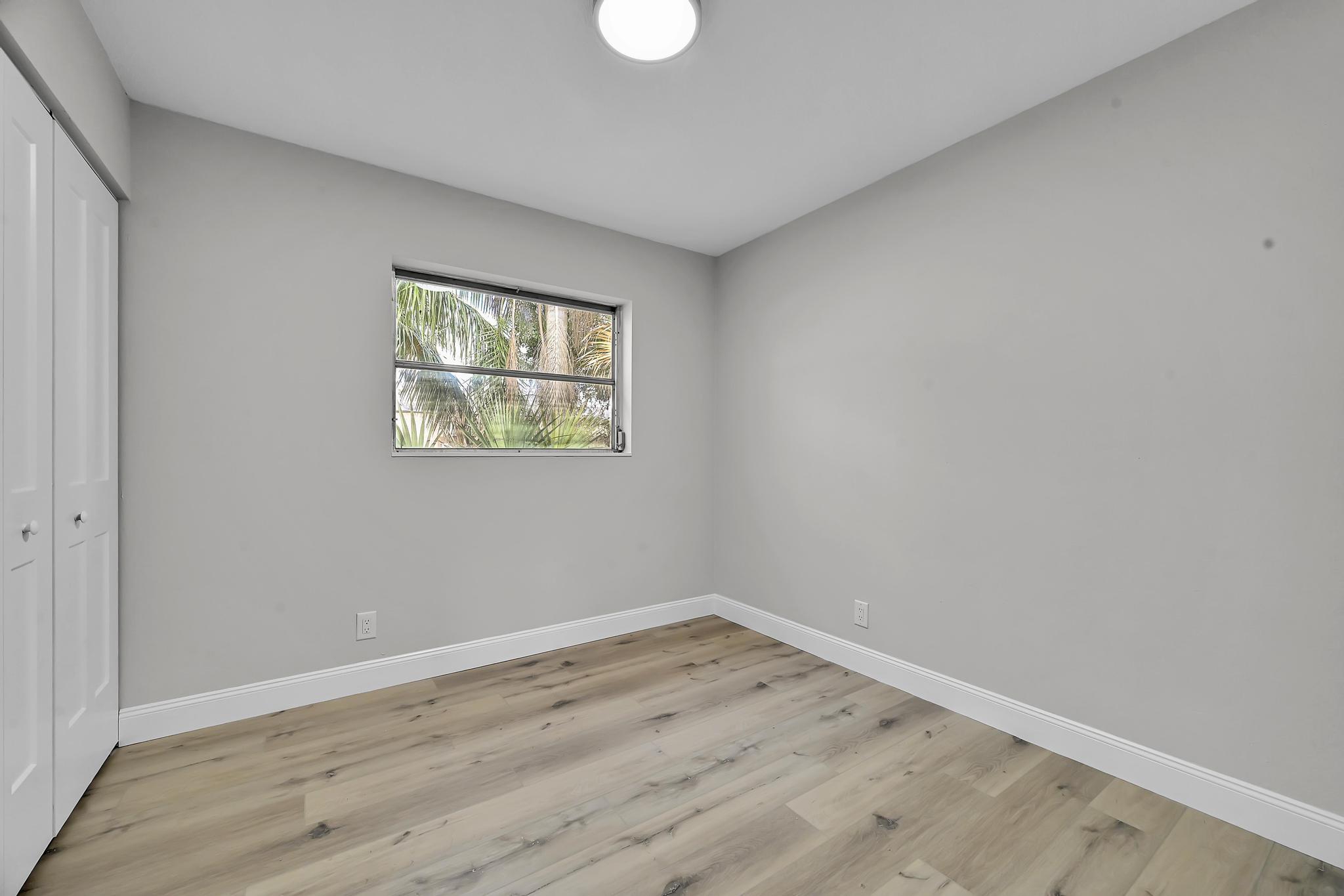 8487 Southeast Begonia Way Hobe Sound, FL 33455 - Photo 14 of 26 wooden floor in an empty room with a window