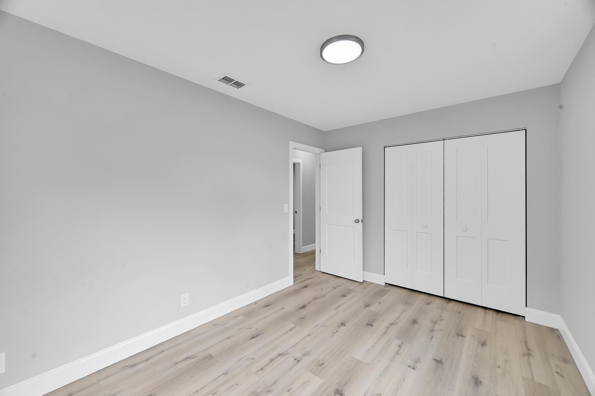 8487 Southeast Begonia Way Hobe Sound, FL 33455 - Photo 18 of 26 a view of an empty room with wooden floor