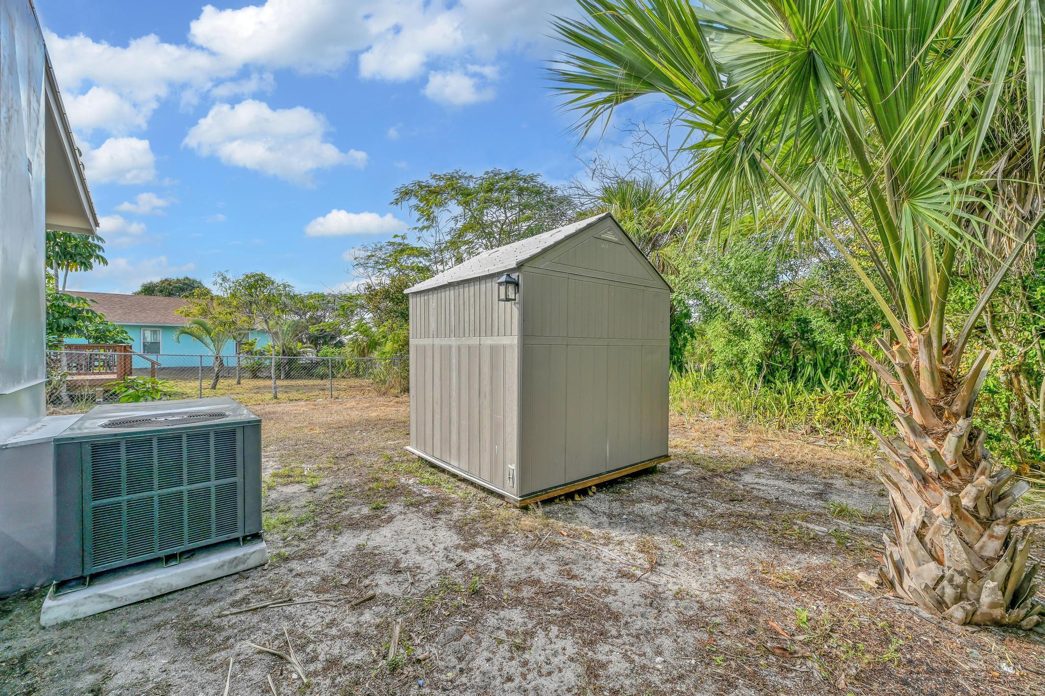 8487 Southeast Begonia Way Hobe Sound, FL 33455 - Photo 26 of 26 a backyard of a house with lots of green space