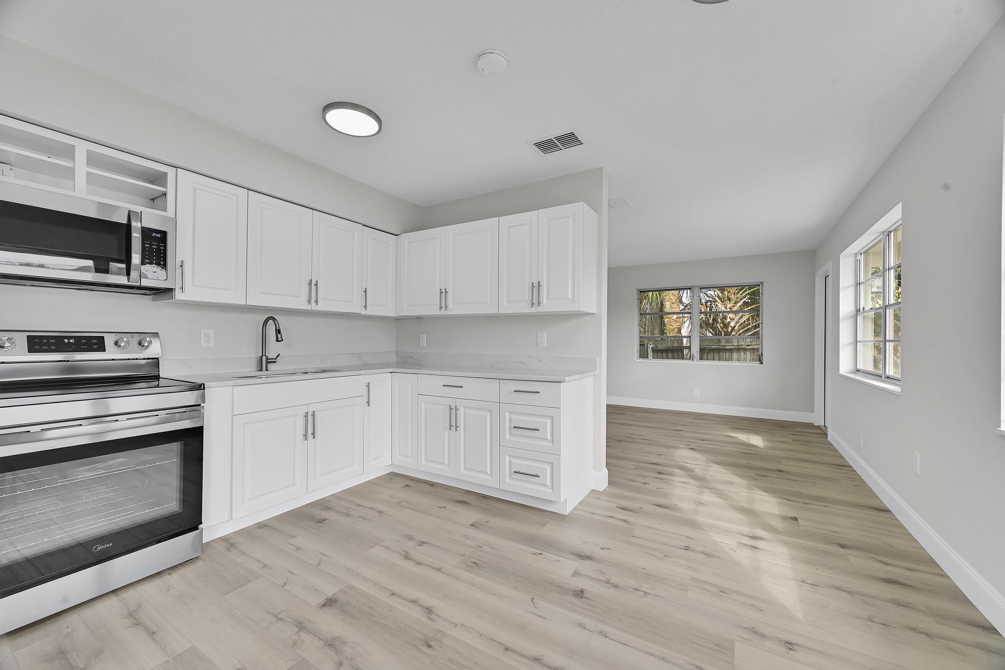 8487 Southeast Begonia Way Hobe Sound, FL 33455 - Photo 8 of 26 a kitchen with stainless steel appliances granite countertop a stove and a sink