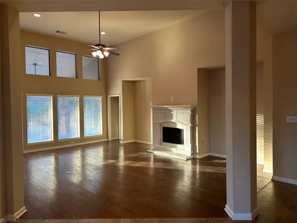 a view of empty room with wooden floor and fireplace