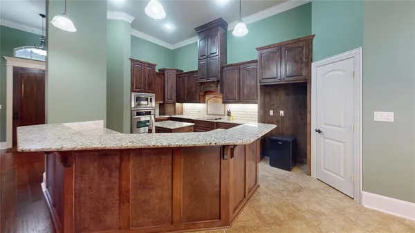 a kitchen with stainless steel appliances granite countertop a sink refrigerator and cabinets