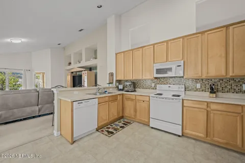 a kitchen with white cabinets and white appliances