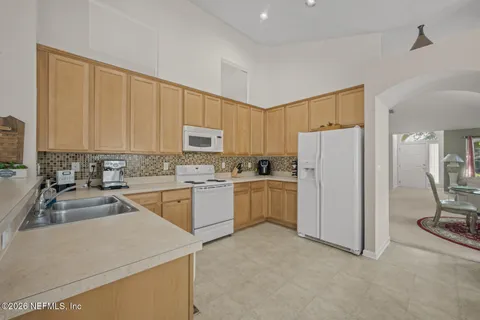 a kitchen with a refrigerator sink stove and white cabinets