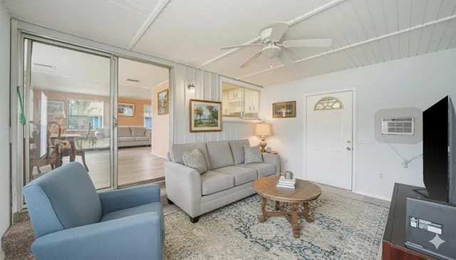 a living room with furniture a large window and a flat screen tv