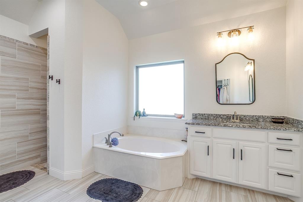 112 Lone Star Way Godley, TX 76044 - Photo 23 of 40 a bathroom with a tub sink and mirror