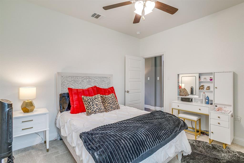 112 Lone Star Way Godley, TX 76044 - Photo 27 of 40 a bedroom with a large bed and a chandelier