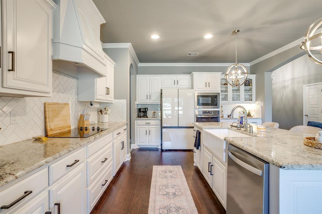112 Lone Star Way Godley, TX 76044 - Photo 9 of 40 a large kitchen with stainless steel appliances kitchen island granite countertop a sink and cabinets