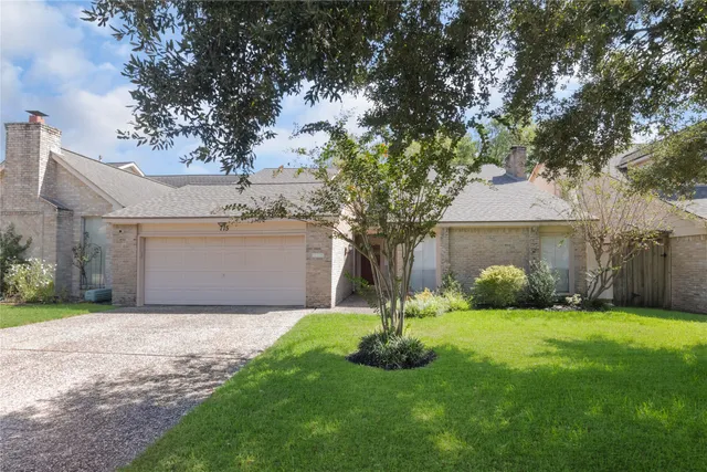 a front view of a house with a yard and tree