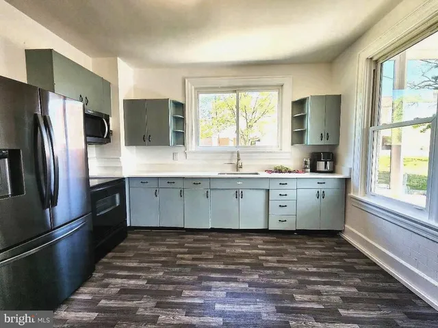 a view of a kitchen sink a window and chandelier