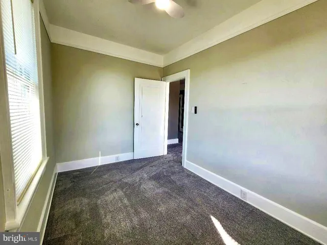 a view of empty room with window and ceiling fan