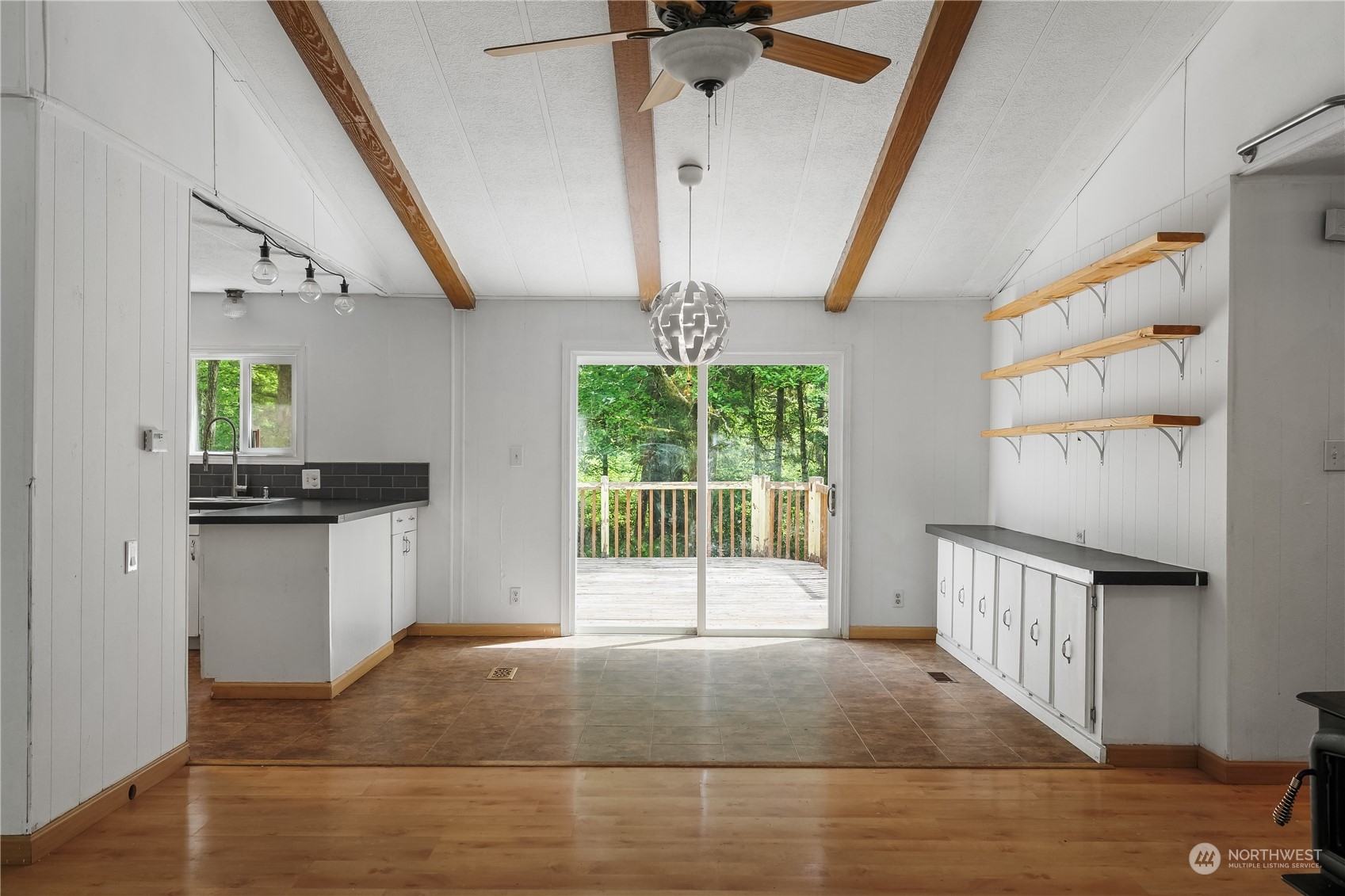 7342 Steamboat Island Road Northwest Olympia, WA 98502 - Photo 11 of 40 a open kitchen with stainless steel appliances kitchen island granite countertop a refrigerator a sink dishwasher and white cabinets with wooden floor