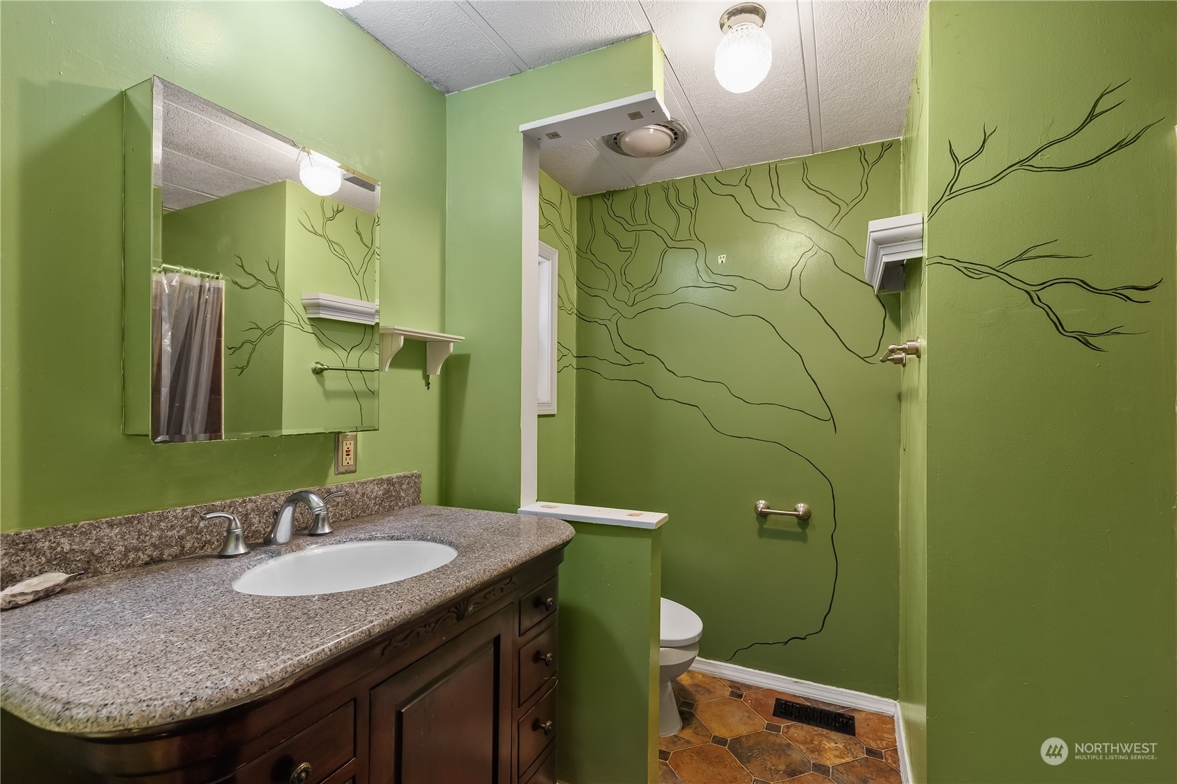 7342 Steamboat Island Road Northwest Olympia, WA 98502 - Photo 25 of 40 a bathroom with a granite countertop toilet sink and mirror