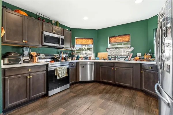 a kitchen with stainless steel appliances a sink cabinets and a window