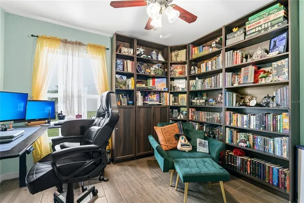 a view of a workspace with furniture and a bookshelf