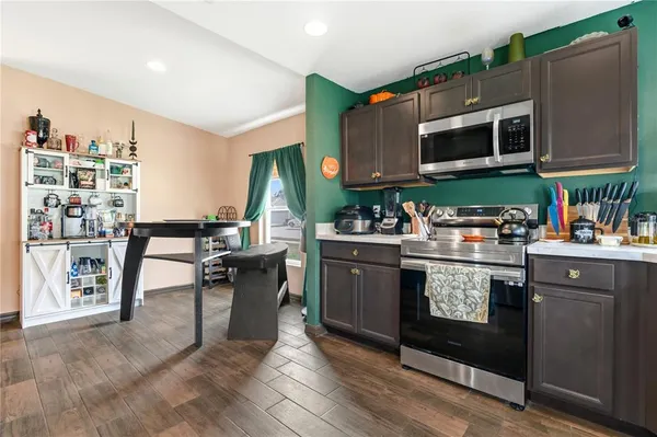 a kitchen with stainless steel appliances granite countertop a stove a sink and a microwave