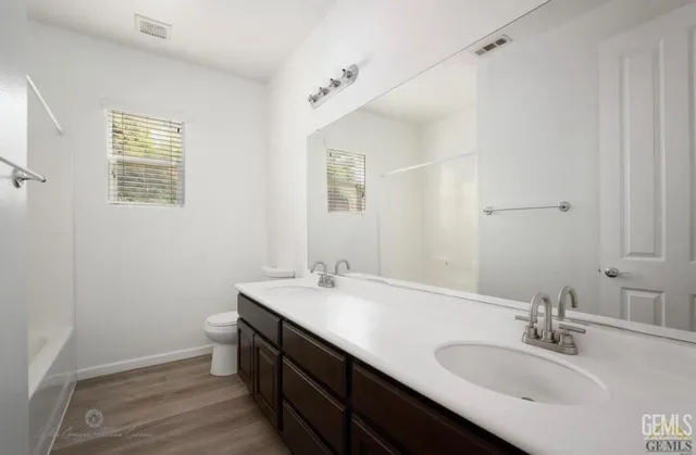 a bathroom with a sink a toilet and a mirror