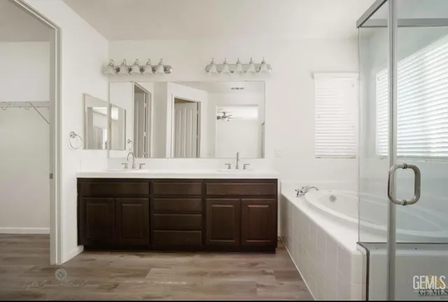 a spacious bathroom with a tub sink and mirror