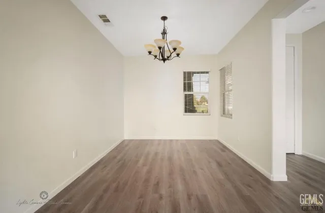 a view of wooden floor chandelier and closet in a room