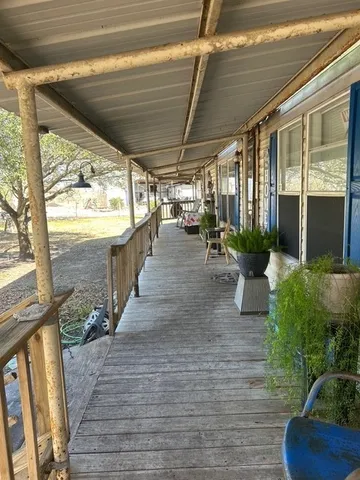 a view of a porch with furniture and floor to ceiling windows