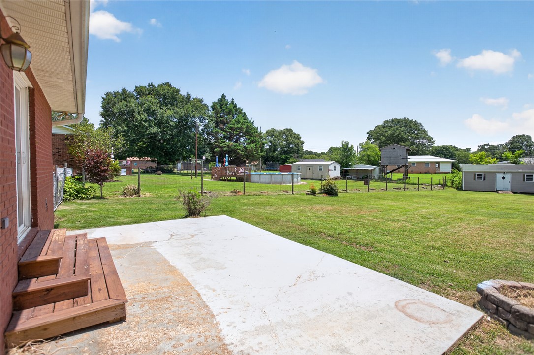 113 Greenfield Avenue Pendleton, SC 29670 - Photo 27 of 40 A spacious backyard retreat features an inviting above-ground pool and ample room for outdoor activities.