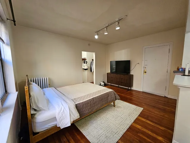 a bedroom with a bed and a flat screen tv