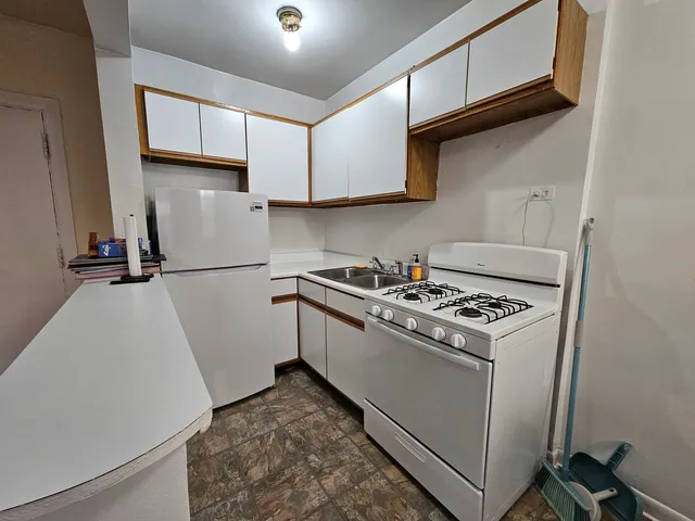 a kitchen with granite countertop a sink stove and refrigerator