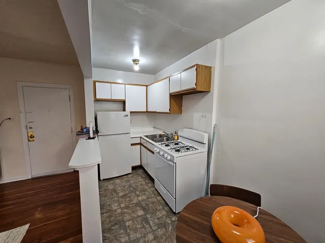 a kitchen with a sink cabinets and wooden floor