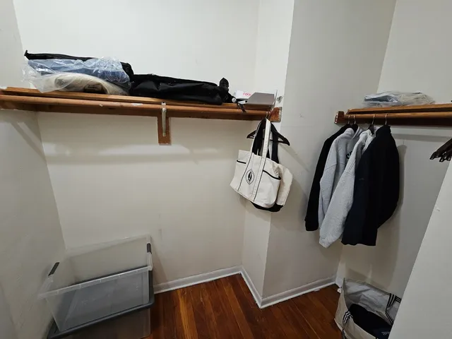 a view of walk in closet with clothes and shoes