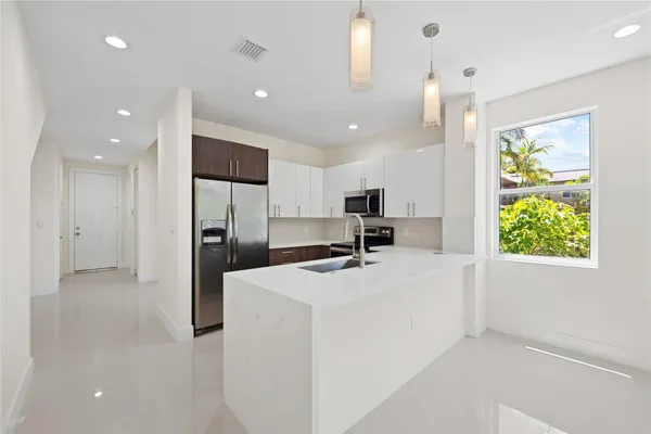 a kitchen with stainless steel appliances kitchen island a refrigerator sink and stove