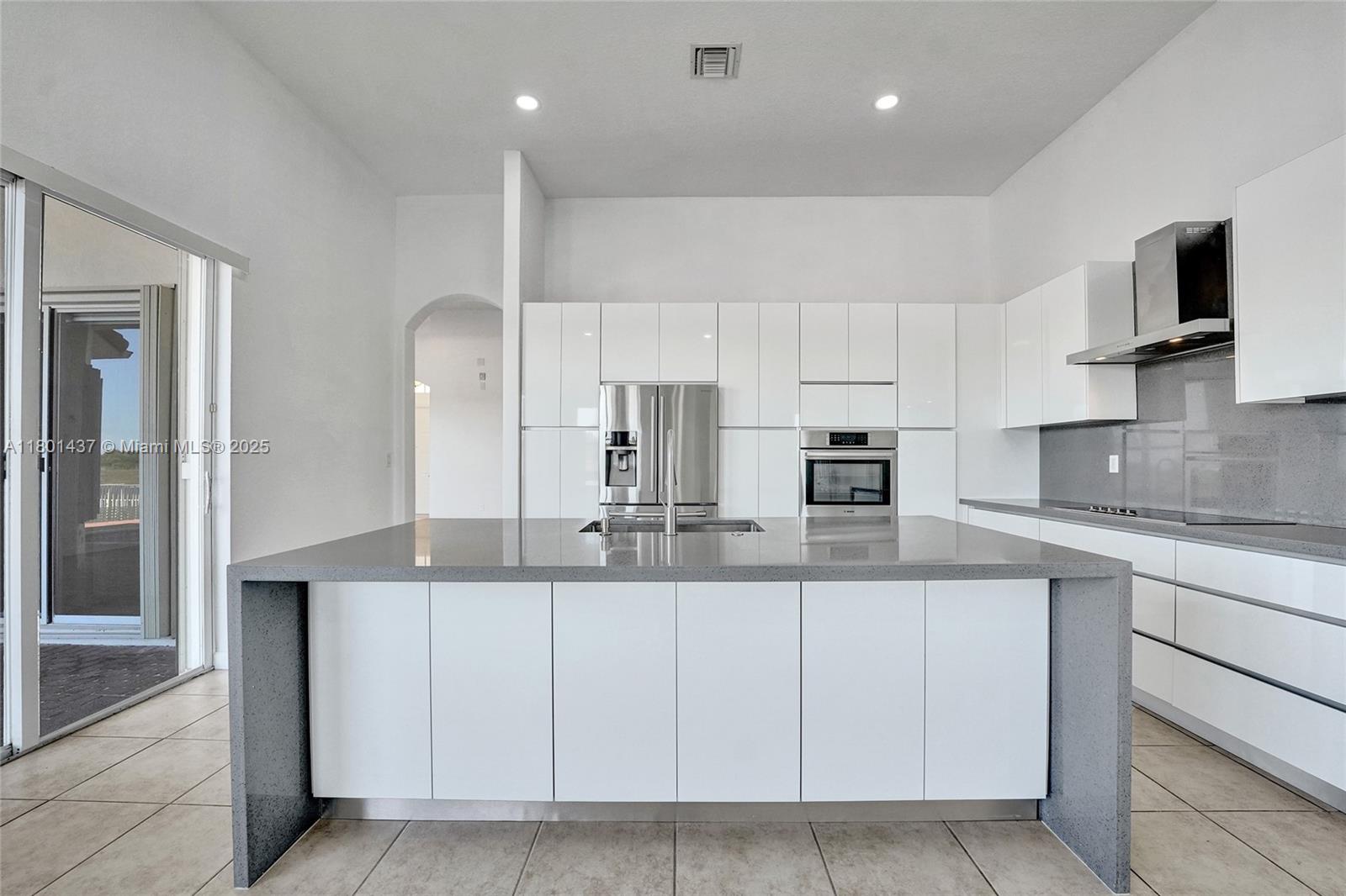 3360 Southwest 195th Terrace Miramar, FL 33029 - Photo 22 of 65 a kitchen with kitchen island granite countertop a sink and white cabinets