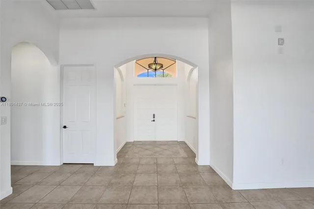 a large white kitchen with a sink and dishwasher a stove top oven with wooden floor